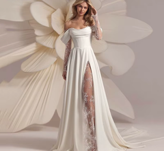 Woman in a white wedding dress with floral lace details against a floral background