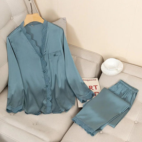 Blue satin pajama set with lace trim on a beige sofa.