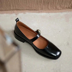Black shoe with brown insole on a light surface