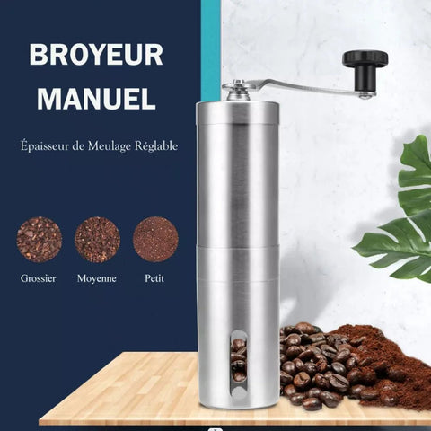 Manual coffee grinder with coffee beans on a wooden surface and plant background