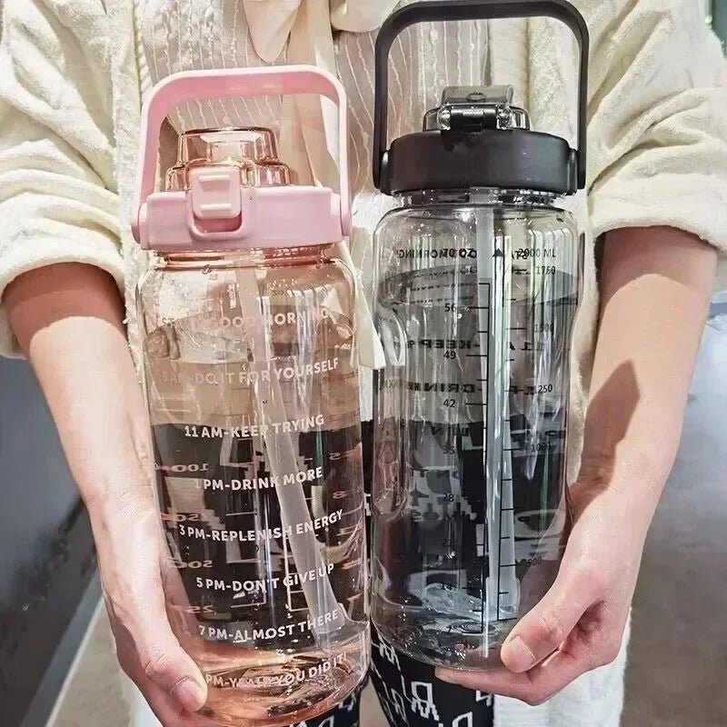 Two water bottles held by a person, one pink and one clear with black lid.