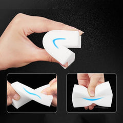 Hand holding a white foam product with blue accents, demonstrating its use on a black background.