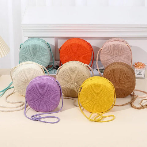 Assorted colorful round woven bags on a light surface with a neutral background