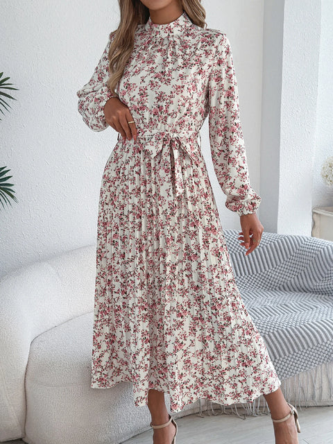 Woman wearing a floral dress in a minimalistic room.