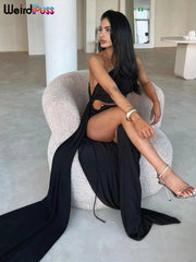 Woman in a black dress sitting on a chair in a modern interior setting.