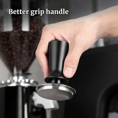 Hand holding a black and silver coffee tamper with text 'Better grip handle' above it.