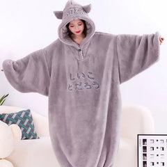 Person wearing a gray fleece onesie with cat ears on a white background