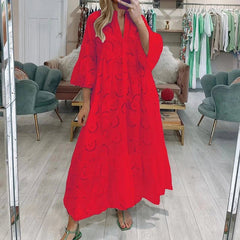 Person wearing a red dress with black patterns in a clothing store.