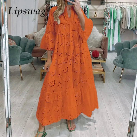Person wearing an orange dress with cut-out patterns in a store setting.