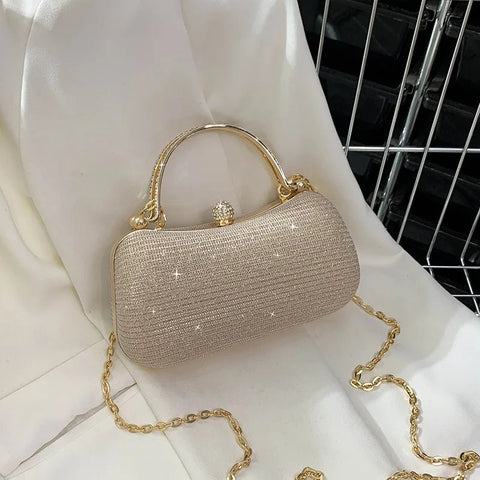Sparkly handbag with gold chain on a white surface