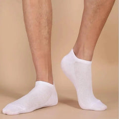 White ankle socks worn on a beige background