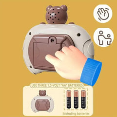 Hand pressing a button on a bear-shaped device with battery information on a yellow background