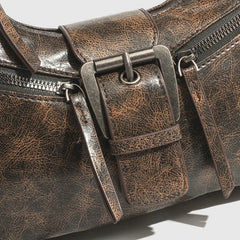 Close-up of a brown leather bag with a buckle on a light gray background