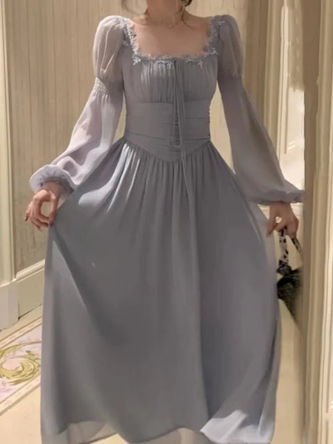 Woman wearing a light blue dress with long sleeves in an indoor setting