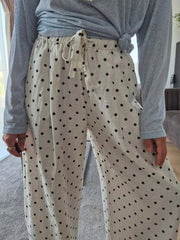 Person wearing beige pants with black polka dots and a gray long-sleeve shirt.