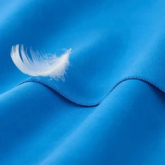 White feather on a blue fabric surface