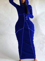 A woman wearing a blue hooded maxi dress with line stitching and flared sleeves.