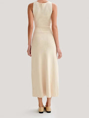 Woman wearing a beige sleeveless dress on a light gray background