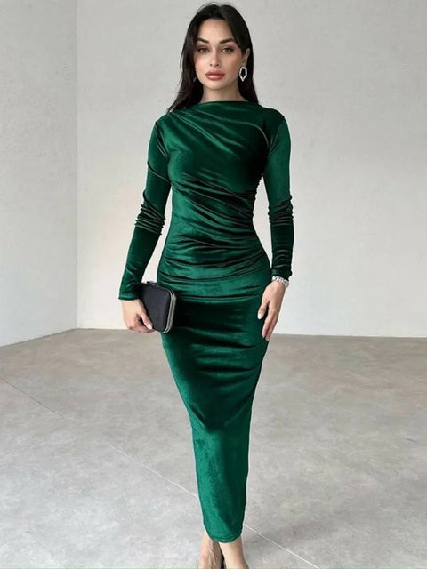 Woman wearing a green dress holding a clutch in an indoor setting