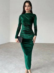Woman wearing a green dress holding a clutch in an indoor setting