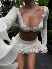 White textured long-sleeve top and skirt set with a blurred background