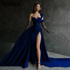 Woman in a long blue dress with a high slit against a dark background