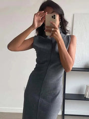 Person wearing a gray sleeveless dress taking a mirror selfie.