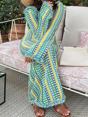 Person wearing a colorful patterned dress sitting on a couch outdoors.