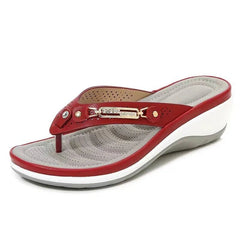 Red and white sandal with a decorative strap on a white background