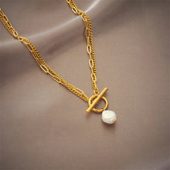 Gold necklace with a pearl pendant on a brown background