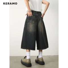 Person wearing dark denim wide-leg pants with a white background and 'KERAMO' branding.