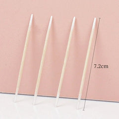 Four white candles of different lengths on a pink background with measurement text.