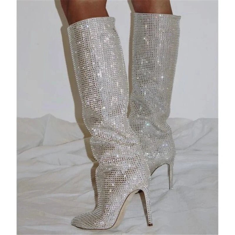 Silver glittery knee-high boots on a white background