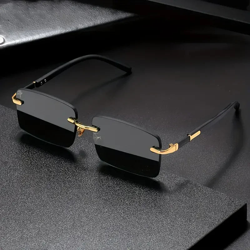 Black rimless sunglasses with gold accents on a dark textured surface