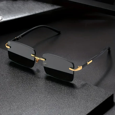 Black rimless sunglasses with gold accents on a dark textured surface