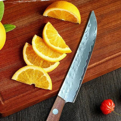 Sliced oranges on a wooden cutting board with a chef's knife.