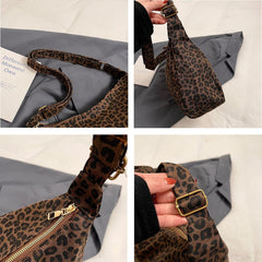 Leopard print bag with gold buckle and zipper on a gray surface.