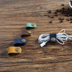 Leather cable ties on a wooden surface with coffee beans