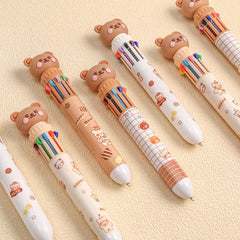 Set of colorful pens with bear-shaped ends on a beige background