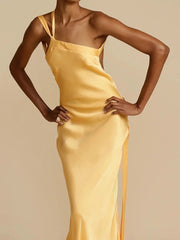 Woman wearing a yellow satin slip dress against a beige background
