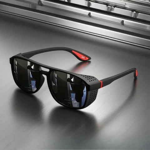 Black sunglasses with red accents on a reflective surface