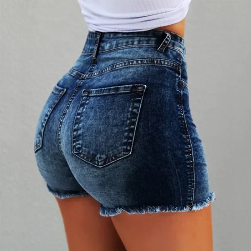 Blue denim shorts worn by a person on a gray background