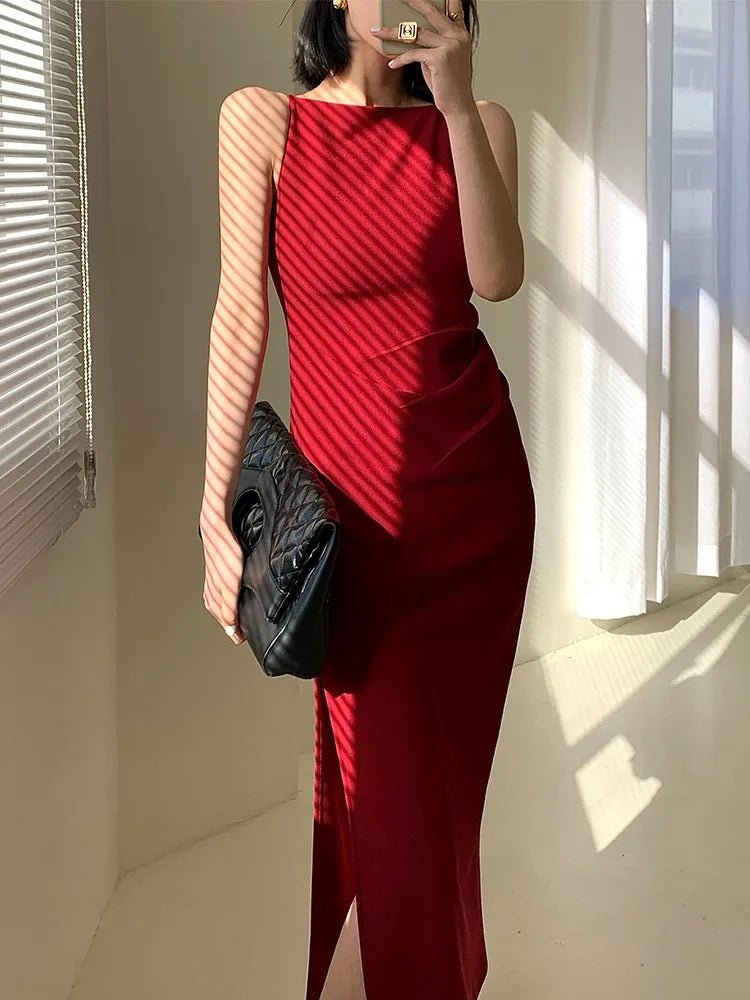 Person wearing a red dress holding a black clutch in a room with sunlight streaming in.