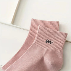 Pair of pink socks with text on a light background
