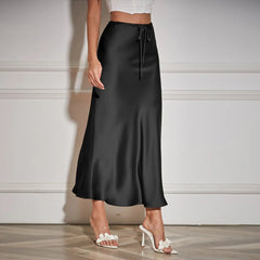 Black satin skirt worn by a person on a neutral background