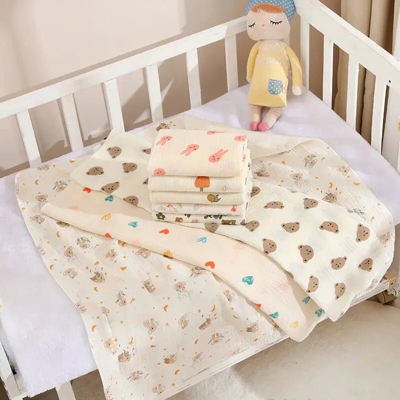 Baby blankets with cartoon patterns on a crib with a plush toy.