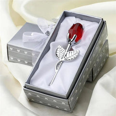 Decorative rose with red gemstone in a gift box on a white background