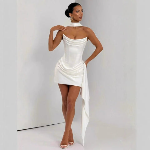 Woman wearing a white dress with a high collar against a plain background