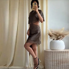 Person wearing a brown lace outfit taking a mirror selfie.