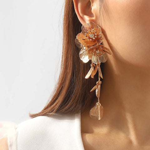 Close-up of a woman wearing a floral earring with a plain background